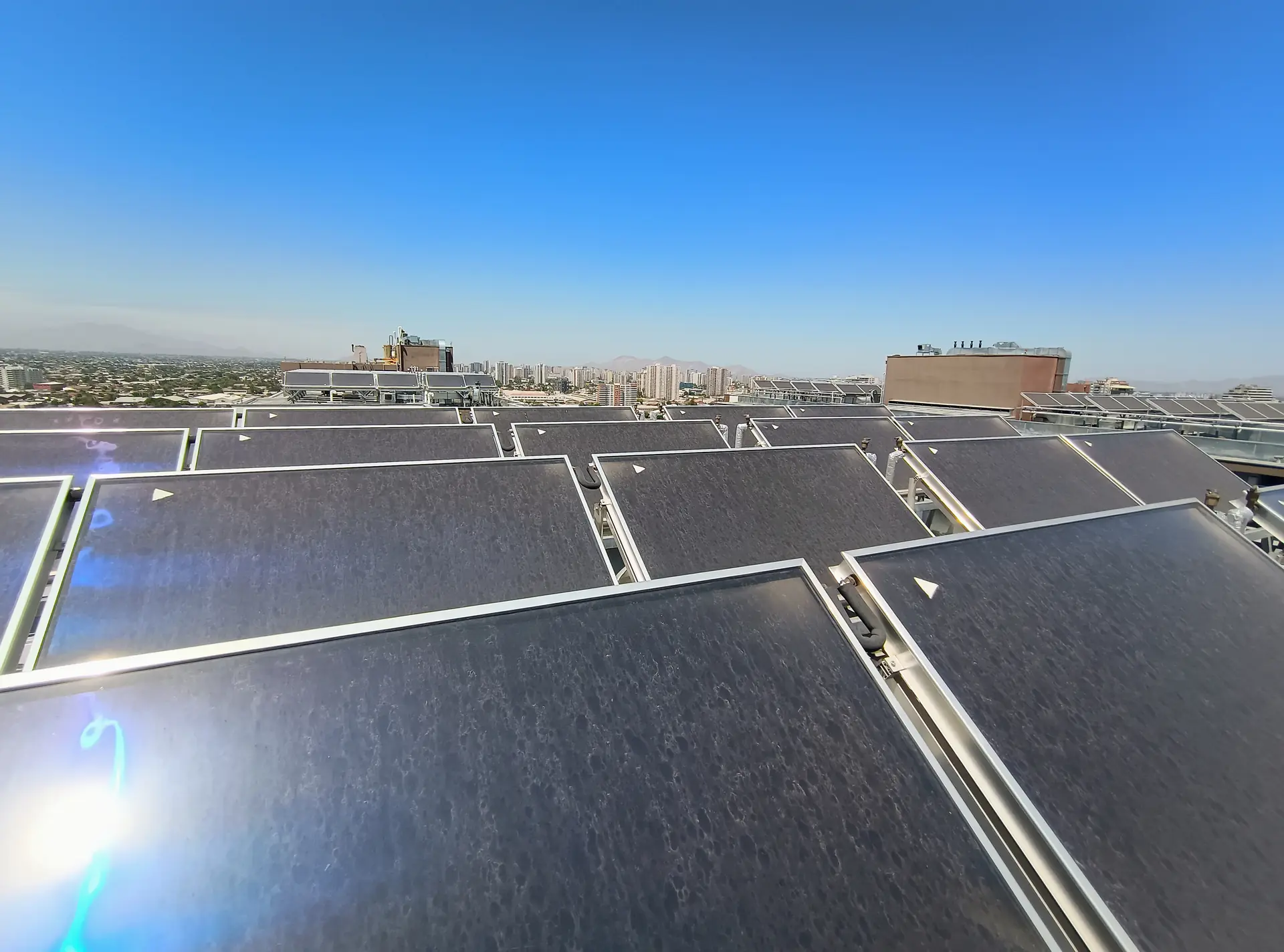Colectores solares térmicos en la azotea de un edificio en Santiago